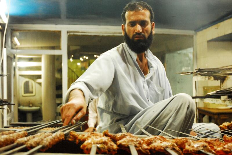 A man cooks barbacue food on the popular "Anarkali" food street, one of many vibrant bazaar food areas, Lahore, Pakistan by Matthew Tabaccos for The National.21.12.08