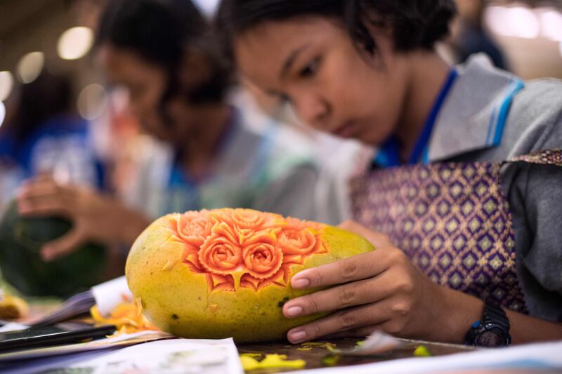 A Thai girl carves floral patterns into a papaya during a fruit and vegetable carving competition in Bangkok. Robert Schmidt / AFP
