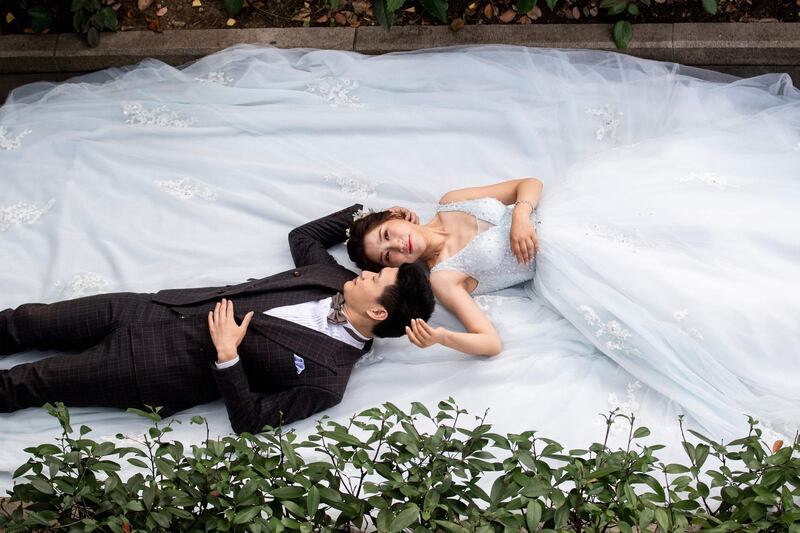 A couple pose for a wedding photographer in a park in downtown Shanghai, Chna. Johannes Eisele / AFP