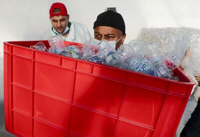 ABU DHABI, UNITED ARAB EMIRATES, Jan 14  – 2020 :-  Jasim Al Zabi (right black cap) and Ismail Juma (left) from Zayed Higher Organization for People of Determination putting plastic bottles into the crushing machine during the recycling workshop held at Zayed Agricultural Center for Development and Rehabilitation in Abu Dhabi. (Pawan Singh / The National) For News. Story by Haneen