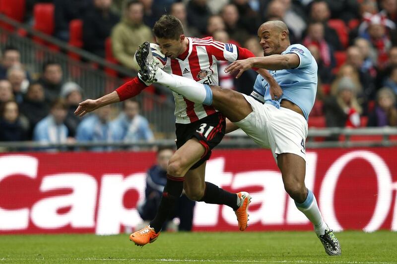 Sunderland's Italian striker Fabio Borini, left, manages to keep possession of the ball against a challenge from Manchester City's Belgian defender Vincent Kompany, right, on his way to scoring the opening goal during the League Cup final. Adrian Dennis / AFP