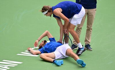 Alexander Zverev checks on Daniil Medvedev after his fall during their match at Indian Wells. AFP