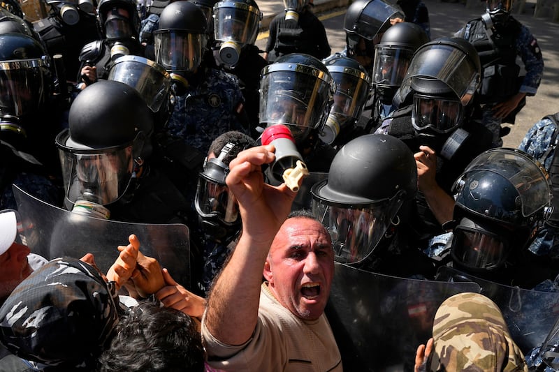 A retired member of the Lebanese security forces holds a fired tear gas canister. AP Photo 