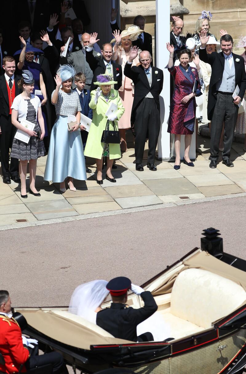 WINDSOR, ENGLAND - MAY 19: Prince Harry, Duke of Sussex salutes members of the Royal family including (L-R) Lady Louise Windsor, Sophie, Countess of Wessex, James, Viscount Severn, Queen Elizabeth II, Princess Michael of Kent, Prince Edward, Earl of Wessex, Prince Philip, Duke of Edinburgh, Princess Anne, Princess Royal and Vice Admiral Sir Timothy Laurence as he and his wife the Duchess of Sussex ride in an open-topped carriage through Windsor Castle after their wedding in St George's Chapel on May 19, 2018 in Windsor, England.  (Photo by Andrew Milligan - WPA/Getty Images)