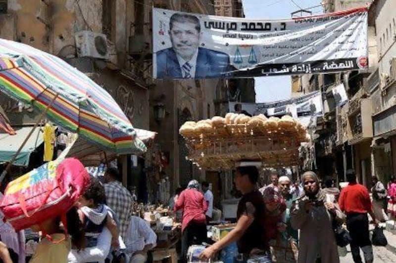 A poster of Egypt's Muslim Brotherhood candidate Mohammed Morsi strewn across a crowded street in Cairo's Al Hussein district. Analysts say if Mr Morsi becomes president, control of Egypt's feared intelligence and security services could boost the Brotherhood's transnational aims.