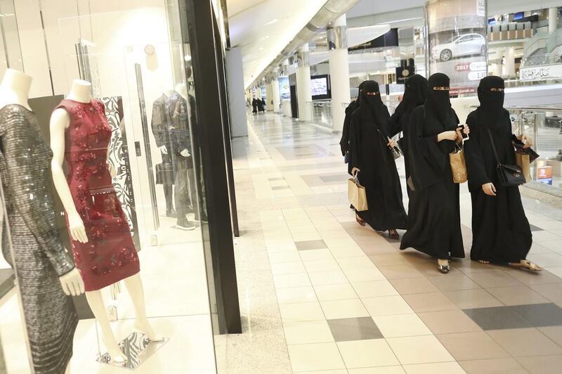 Shoppers walk past clothing stores in the Kingdom Centre shopping mall in Riyadh. Saudi Arabia, has asked malls, supermarkets and restaurants and cafes to hire more citizens as it looks to boost jobs. Bloomberg