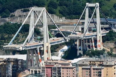TOPSHOT - A general view shows the two pylons of Genoa's Morandi motorway bridge that are to be destroyed with explosives, seen in red on the concrete structure below, on June 27, 2019 in Genoa. Some of the remains of Genoa's Morandi motorway bridge are set to be destroyed on June 28 almost eleven months after its partial collapse during a storm killed 43 people and injured dozens. / AFP / Vincenzo PINTO                      
