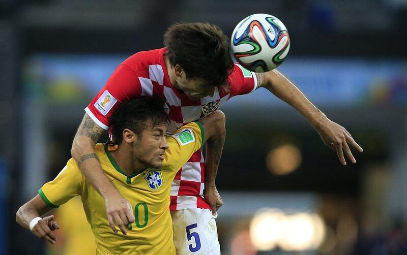 Neymar, below, of Brazil vies for a header with Vedran Corluka, above, of Croatia during the opening match to World Cup 2014 on Thursday night in Sao Paulo, Brazil. Adrian Dennis / AFP