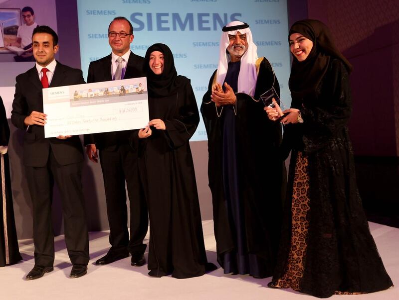 Sheikh Nahyan bin Mubarak, Minister of Culture, Youth and Community Development, and Dietmar Siersdorfer, the chief executive of Siemens Middle East, present the award to Team Cool Clay – (l-r) Majid Abuabdoun, Camilia Aokal and Fatima Al Madhloum – at the Siemens Student Awards in Abu Dhabi last night. Sammy Dallal / The National