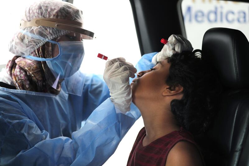 A health worker collects a sample at a drive-through coronavirus testing centre at the Ain Shams University in Cairo, Egypt.  EPA