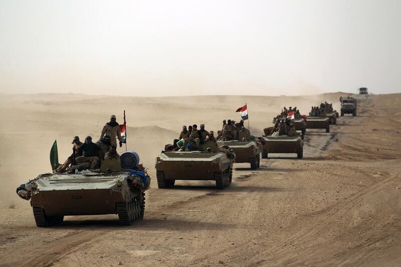 TOPSHOT - Iraqi forces and members of the Hashed al-Shaabi (Popular Mobilisation units) advance towards the city of al-Qaim, in western Anbar province, on the Syrian border as they fight against remnant pockets of Islamic State group jihadists on November 2, 2017. / AFP PHOTO / AHMAD AL-RUBAYE