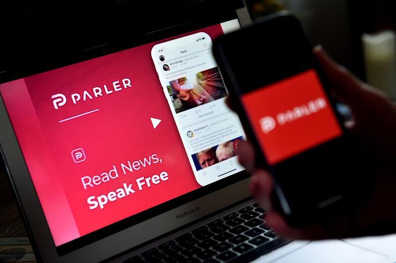 (FILES) In this file photo taken on July 01, 2020 an illustration picture shows social media application logo from Parler displayed on a smartphone with its website in the background in Arlington, Virginia. Apple on January 9, 2021, followed Google and removed the Parler app from its mobile store for allowing "threats of violence," after the deadly attack on the US Capitol by supporters of President Donald Trump. - 
 / AFP / Olivier DOULIERY
