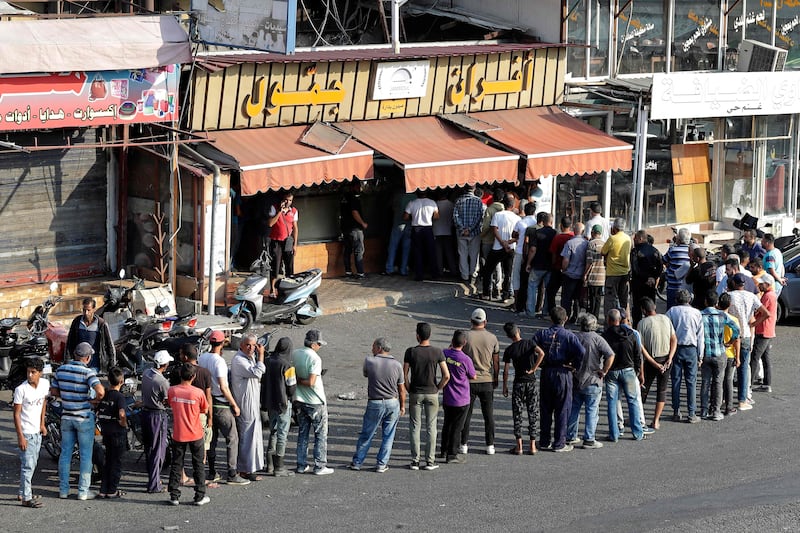 People queue at a bakery to buy bread in Sidon, southern Lebanon, as the country's shortage of fuel and wheat deepens. AFP