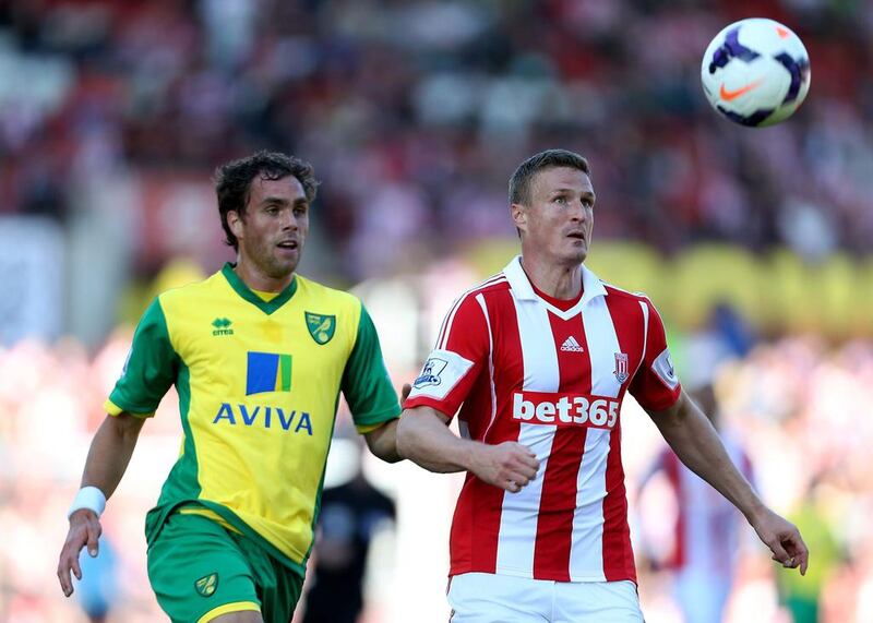 Norwich City’s Johan Elmander, left, and Stoke City’s Robert Huth run for the ball. Lynne Cameron / PA