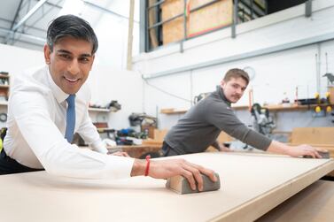 British Prime Minister Rishi Sunak, left, helps to make a wooden door with carpentry apprentice Adam Jellis during a visit to Pinewood Studios in Slough, Buckinghamshire, England, Monday Jan.  22, 2024.  (Stefan Rousseau, Pool Photo via AP)