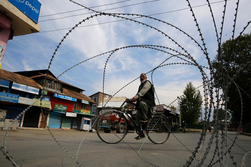 A man rides his bicycle during shutdown in Srinagar, Kashmir. Farooq Khan / EPA
