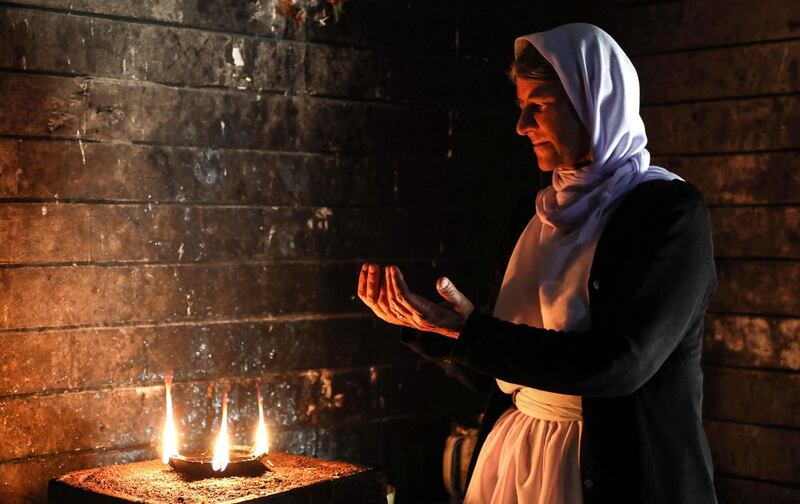 An Iraqi Yazidi woman prays at the Temple of Lalish, in a valley near the Kurdish city of Dohuk about 430km northwest of the capital Baghdad, on July 16, 2019. AFP