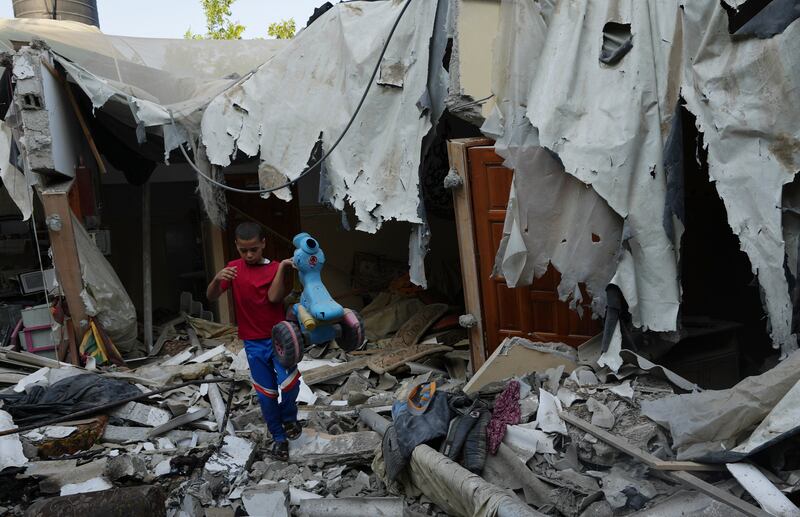 Mohammad Arada removes a tricycle from the rubble of his home after it was destroyed by an Israeli air strike, in the Rafah refugee camp. AP