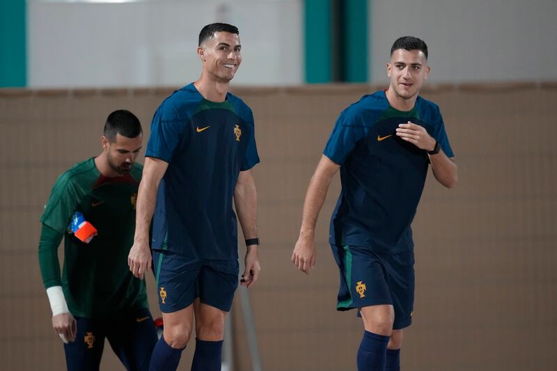 Portugal's Cristiano Ronaldo, centre, Diogo Dalot, right, and goalkeeper Diogo Costa, left, arrive for training. AP