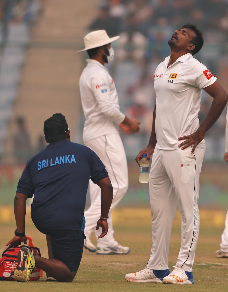Sri Lanka's Lahiru Gamage, right, reacts as the game was briefly stopped during the second day of their third test cricket match in New Delhi. Altaf Qadri / AP Photo