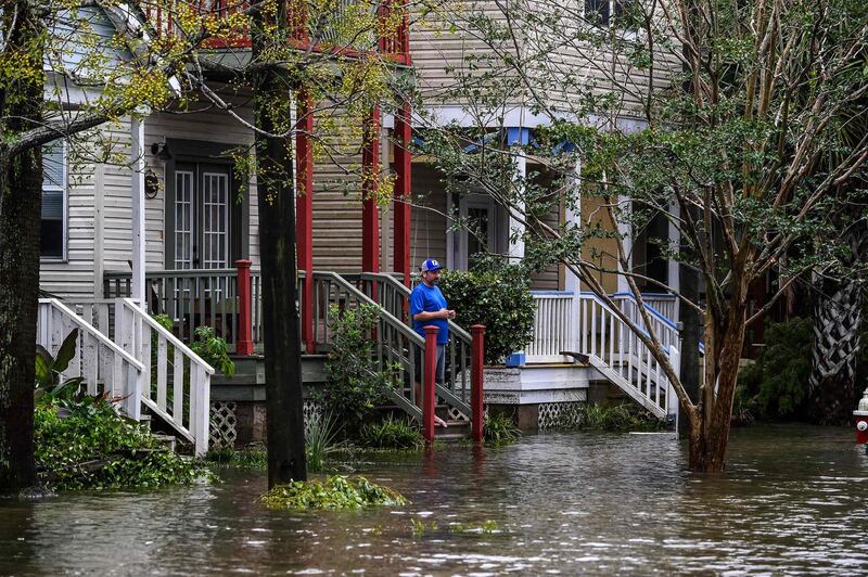 A man, standing outside of his home,watches a street flooded by Hurricane Sally in Pensacola, Florida.  AFP