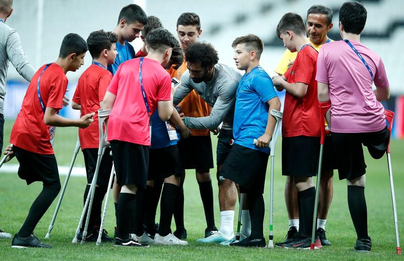 Liverpool's Mohamed Salah signs autographs for children at the end of a training session at the Besiktas Park Stadium, in Istanbul. AP Photo
