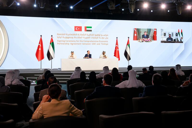 Sheikh Mohamed and President Recep Tayyip Erdogan of Turkey virtually attend the ceremony as Abdulla Bin Touq, UAE Minister of the Economy, right, Mehmet Muş, Minister of Trade of Turkey, centre, and Dr Thani Al Zeyoudi, UAE Minister of State for Foreign Trade complete formalities. Photo: Hamad Al Kaabi / UAE Presidential Court 