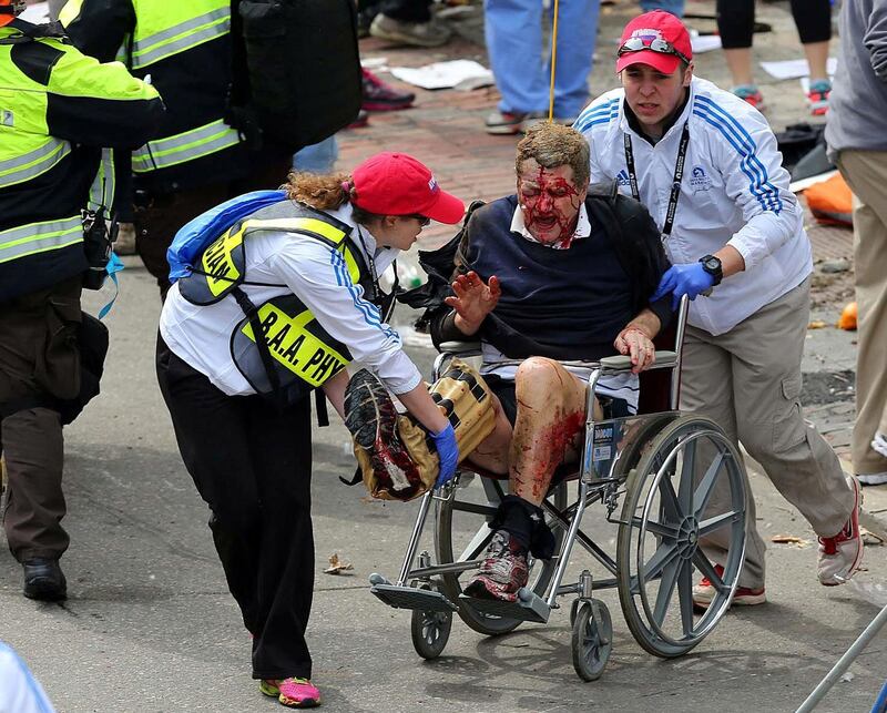 Medical workers aid an injured man at the 2013 Boston Marathon following an explosion in Boston, Monday, April 15, 2013. Two bombs exploded near the finish of the Boston Marathon on Monday, killing at least two people, injuring at least 22 others and sending authorities rushing to aid wounded spectators. (AP Photo/The Boston Globe, David L. Ryan) *** Local Caption ***  APTOPIX Boston Marathon Explosions.JPEG-0f11c.jpg