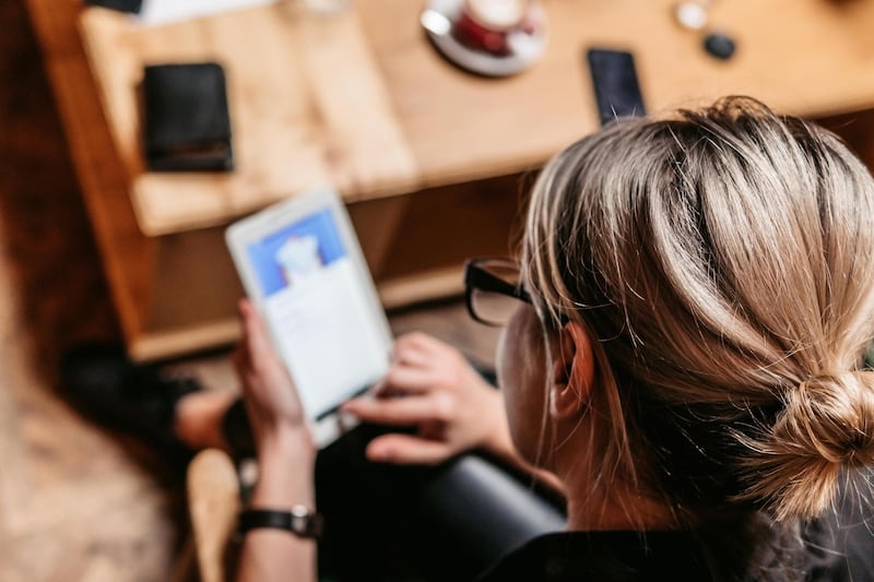 Young woman sitting cafe and checking social media or e-mail on digital tablet. Getty Images