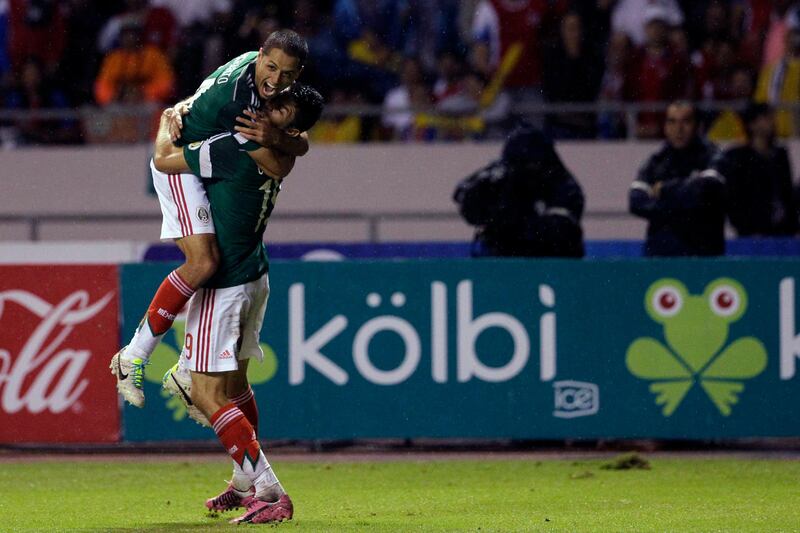 Mexico's Oribe Peralta, right, celebrates with teammate Mexico's Javier Hernandez after scoring during a 2014 World Cup qualifying soccer match in San Jose, Costa Rica, Tuesday, Oct. 15, 2013. (AP Photo/Moises Castillo)