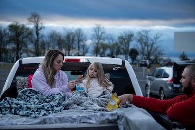 Summer Edwards, Kimberlyn Edwards, and Chance Edwards eat snacks while waiting for the movie to start at the Family Drive-In Theatre during its opening night amid novel coronavirus restrictions on May 1, 2020, in Stephens City, Virginia. The theatre managment implemented special coronavirus policies to insure everyone safety. Virginia Governor Ralph Northam had ordered the closing of nonessential businesses through May 8, he is scheduled to present new guidelines on May 4. / AFP / Brendan Smialowski
