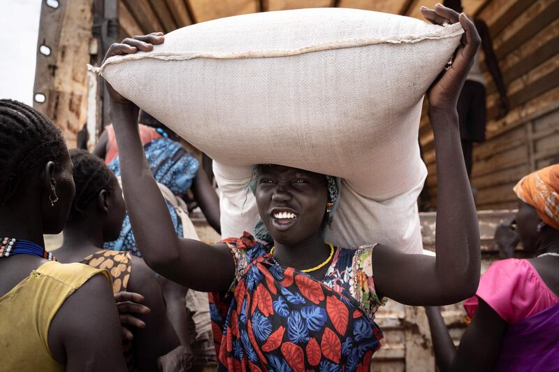 A woman from the Murle ethnic group carries a bag of grain during food distribution by the UN in Gumuruk, South Sudan, after her village was attacked by an armed group. AFP