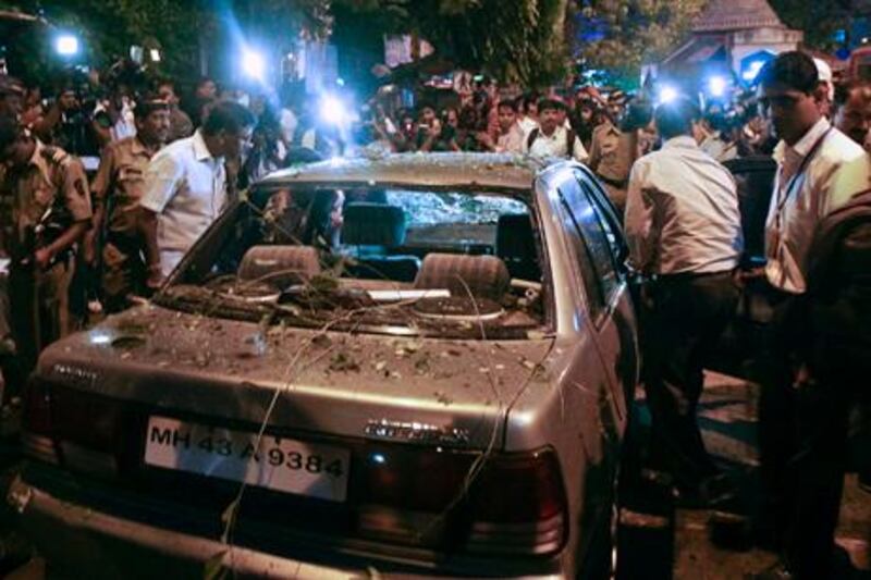 Plain clothed police surround a vehicle which was damaged at the site of an explosion in the Dadar area of Mumbai July 13, 2011. Three explosions rocked crowded districts of India's financial capital of Mumbai during rush hour on Wednesday, killing at least eight people, media said, in the biggest attack on the city since 2008 assaults blamed on Pakistan-based militants.  REUTERS/Stringer   (INDIA - Tags: CIVIL UNREST CRIME LAW)