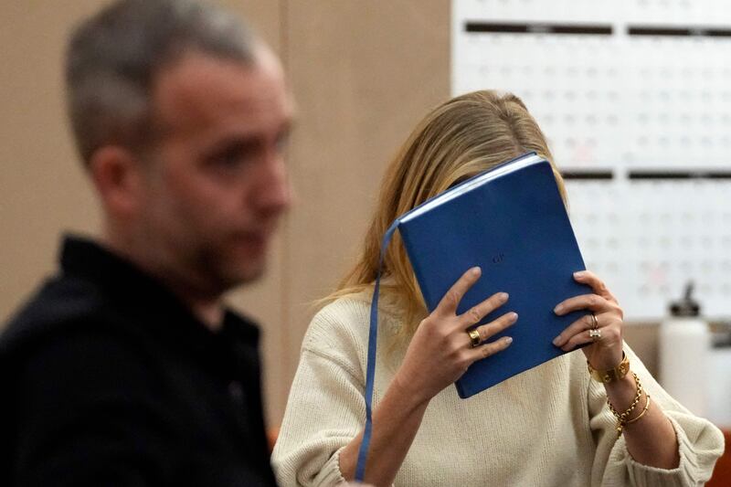 Ms Paltrow hides her face as she leaves the courtroom. AFP