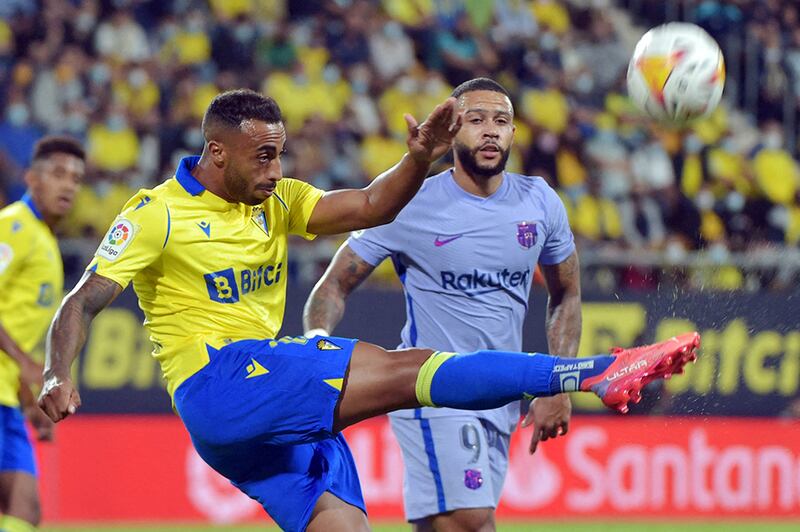 Cadiz defender Carlos Akapo kicks the ball next to Memphis Depay. AFP
