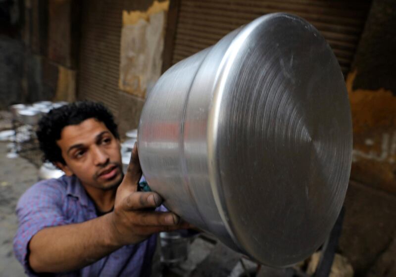 A worker checks an aluminium cookware in a workshop in Cairo, Egypt. Reuters
