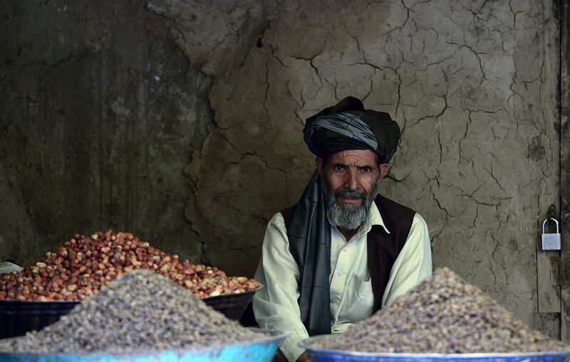 Afghan dry fruits seller looks on as he waits for customers in an old morket in Kabul ahead of the Islamic holy month of Ramadan on July 8, 2013. Throughout the month, devout Muslims must abstain from food and drink from dawn until sunset when they break the fast with the Iftar meal. Traditionally, dates are known as the food the prophet Mohammad ate when he broke from his fast. AFP PHOTO / Massoud HOSSAINI
 *** Local Caption ***  511813-01-08.jpg