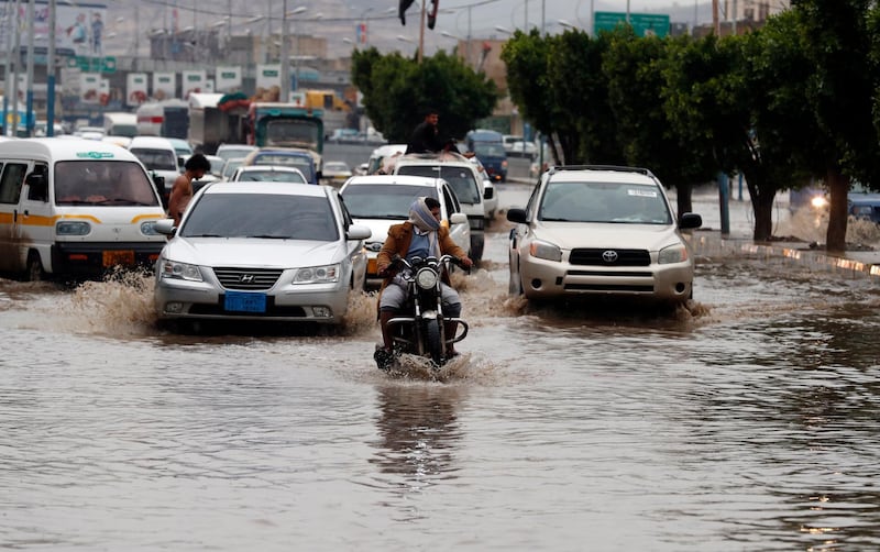Vehicles drive through a flooded street following heavy rains in Sana'a, Yemen.  EPA