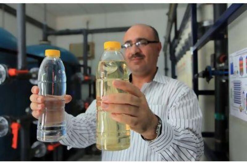 Raid al Essa, the maintenance manager at Al Ain Farms, shows the waste water after recycling, left, and before, right.
