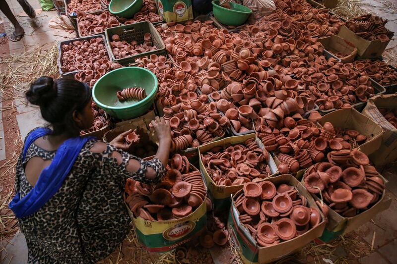 A woman buys earthen lamps in preparation. EPA