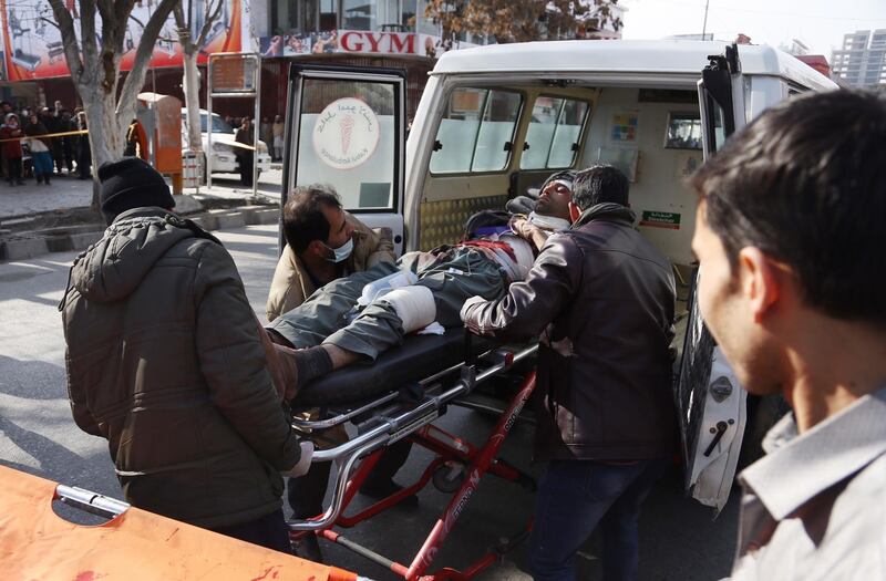 People help carry an injured man to the hospital following a suicide attack in Kabul. Rahmat Gul / AP Photo