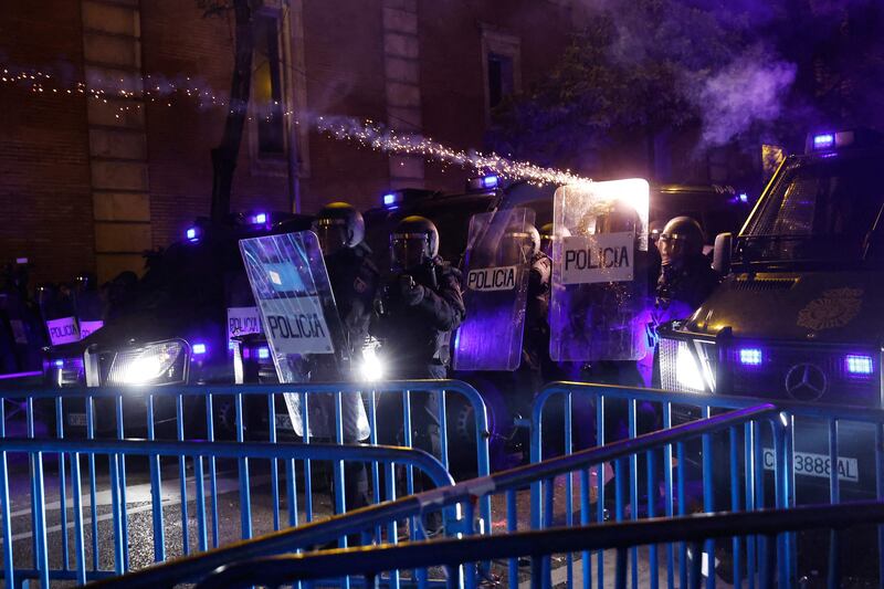 Police use shields to protect themselves from bottle-rockets launched by demonstrators. AFP