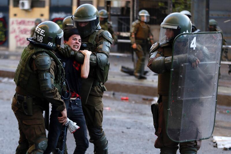 Carabineros Special Forces detain a protester during demonstrations at Plaza Baquedano, in Santiago, Chile. At least 20 people have died since the protest began over a hike in subway fares.  EPA