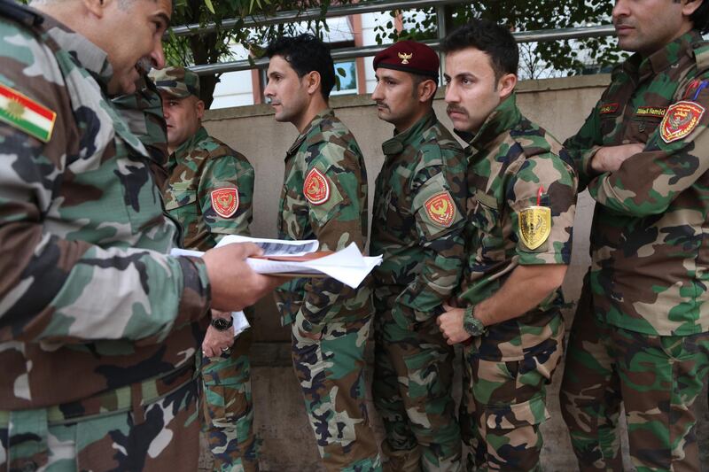 Kurdish Peshmerga fighters wait to vote during a special voting day for the Iraqi legislative parliamentary election at a polling station in Erbil, the capital of the Kurdistan Region in Iraq. Gailan Haji / EPA