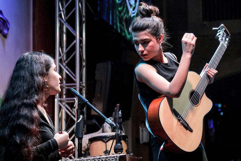 In this picture taken on May 1, 202, Syrian-Kurdish refugees and musicians Norshean Salih (R), 23, and her sister Perwin Salih, 20, perform in Arbil, the capital of the autonomous Kurdish region of northern Iraq.  Onstage in Iraq's Kurdish capital of Arbil, two Syrian sisters played the melancholy music of their people, the Kurds -- melodies that echo their own story of suffering and displacement.  (Photo by Safin HAMID  /  AFP)