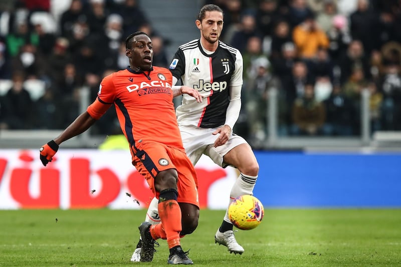 Udinese's Italian forward Stefano Okaka (L) passes the ball under pressure from Juventus' French midfielder Adrien Rabiot. AFP