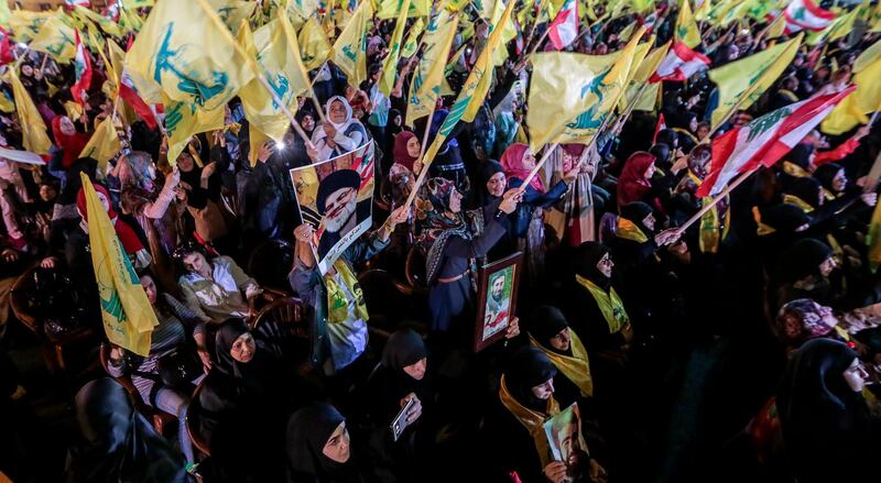 epa06950150 Hezbollah supporters wave Hezbollah flags as they listen to the speech of Hezbollah leader Hassan Nasrallah via a giant screen   in  southern suburb of Beirut, Lebanon, 14 August 2018.  Hassan Nasrallah, the Hezbollah leader, spoke to thousands of supporters gathered at a rally to mark the 12th anniversary of the end of the 2006 July War between Hezbollah and Israel. Supporters at the rally watched his speech on giant screens as it was broadcast from a secret location.  EPA/NABIL MOUNZER