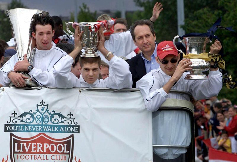In this file photo taken on May 20, 2001 Liverpool's French coach Gerard Houllier, second right, defender Sami Hyypia, left, striker Robbie Fowler and Steven Gerrard, second right, show off their three trophies from an open top bus during a parade through the city of Liverpool. AFP