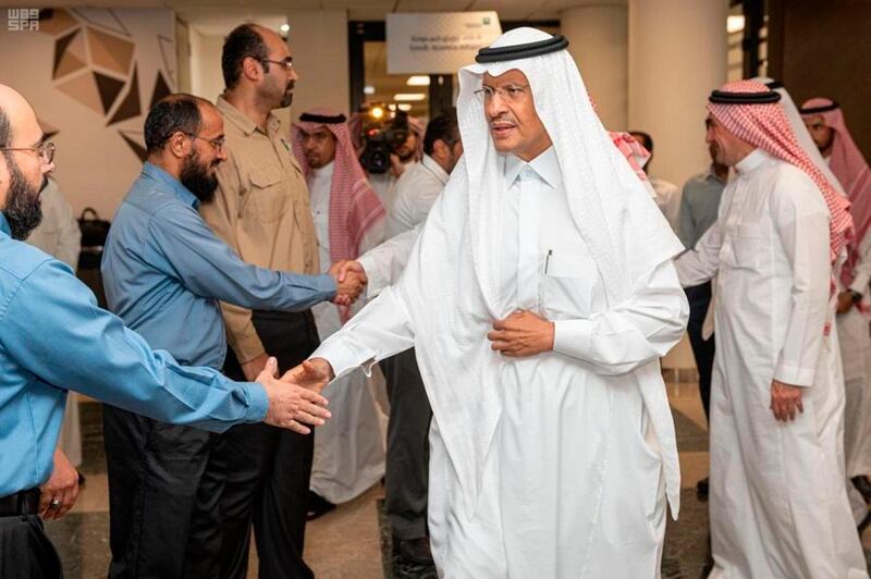 In this Sunday, Sept. 15, 2019, photo released by Saudi Press Agency, SPA, Saudi Energy Minister Prince Abdulaziz bin Salman, center, shakes hands with staff during his visit of the Saudi Aramco plants one day after the attacks in Abqaiq, Saudi Arabia. (Saudi Press Agency via AP)