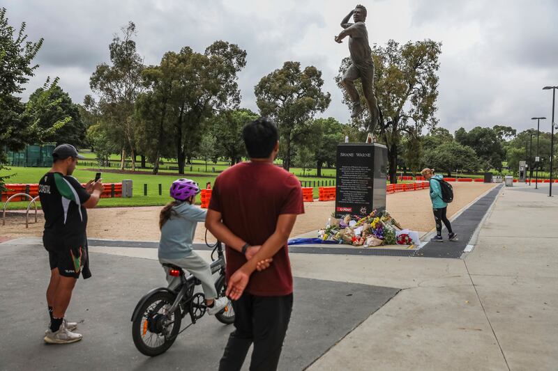 Fans pause at the statue of cricket legend Shane Warne outside the Melbourne Cricket Ground. AP
